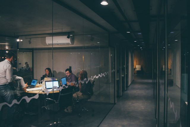 A team sitting at a table with laptops in an all-glass meeting room discussing when to use a map chart.